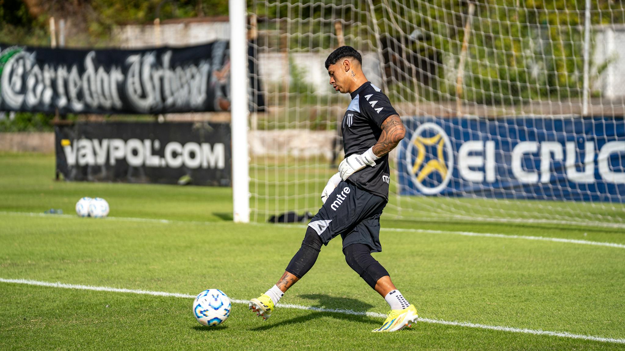 Goalkeeper training outdoors with precision and focus on a sunny field.